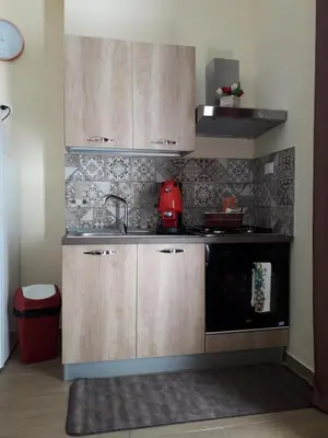 a kitchen with wooden cabinets and a sink at La Casetta del Viale 13 in Palermo