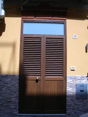 a wooden door in front of a building at La Casetta del Viale 13 in Palermo