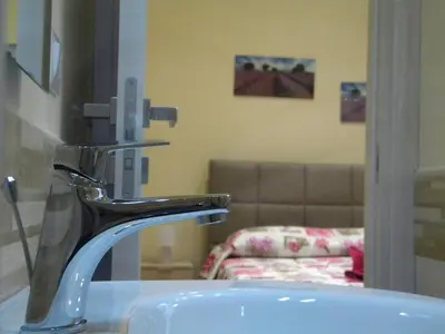 a sink in a bathroom with a couch at La Casetta del Viale 13 in Palermo