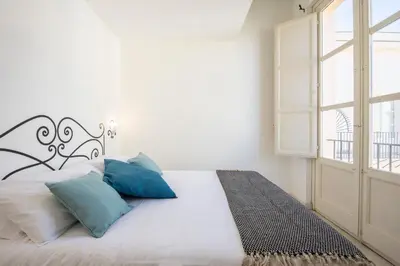 a bedroom with a bed with blue pillows and a window at Palazzo Castrofilippo Apartment by Wonderful Italy in Palermo