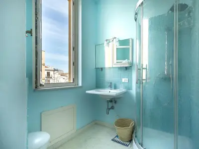 a blue bathroom with a sink and a shower at Palazzo Castrofilippo Apartment by Wonderful Italy in Palermo
