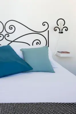 a bed with a black headboard and a blue pillow at Palazzo Castrofilippo Apartment by Wonderful Italy in Palermo