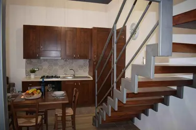 a kitchen with a staircase leading up to a kitchen with a table at Casa Vacanza Mar' illù in Castellammare del Golfo