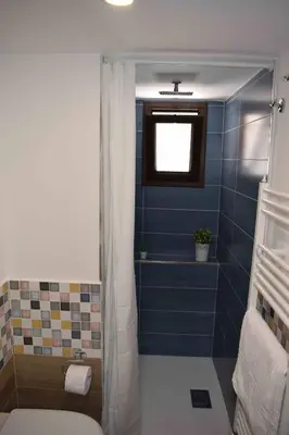 a bathroom with a shower with a blue tiled wall at Casa Vacanza Mar' illù in Castellammare del Golfo