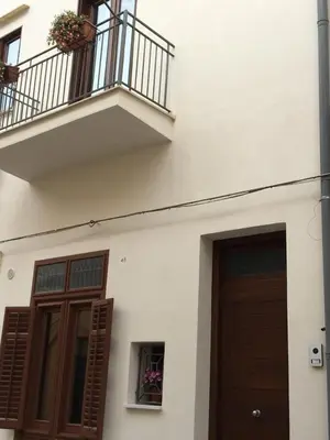 a white building with a door and a balcony at Casa Vacanza Mar' illù in Castellammare del Golfo