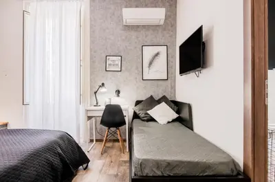 a bedroom with a bed and a desk at Panurban Rooms by Wonderful Italy in Palermo