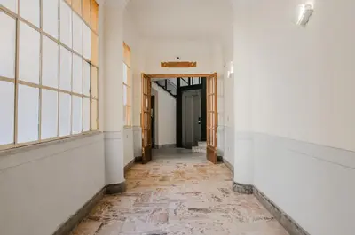 an empty hallway in an old building with windows and a corridor at Panurban Rooms by Wonderful Italy in Palermo