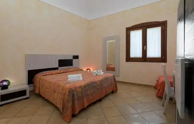 a bedroom with a bed and a tv in it at Angolo Arancio Bed & Breakfast in San Vito lo Capo