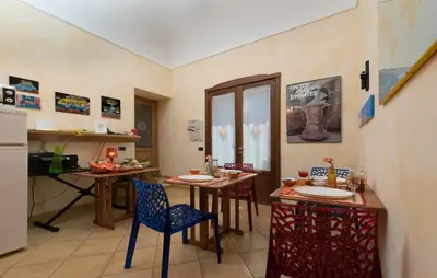 a kitchen with two tables with chairs and a counter at Angolo Arancio Bed & Breakfast in San Vito lo Capo