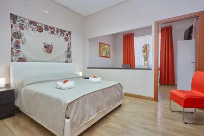 a bedroom with a bed and a red chair at Sturzo 44 in Palermo