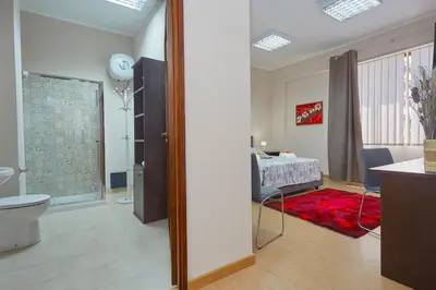 a room with a bedroom with a bed and a bathroom at Sturzo 44 in Palermo