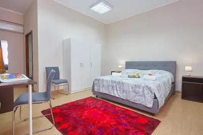 a bedroom with a bed and a red rug at Sturzo 44 in Palermo