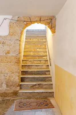 a staircase in a building with a stone wall at Alle Antiche Mura del mercato di Ballarò in Palermo