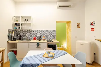 a kitchen with a table and chairs in a room at Alle Antiche Mura del mercato di Ballarò in Palermo