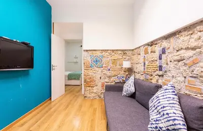 a living room with a couch and a stone wall at Alle Antiche Mura del mercato di Ballarò in Palermo