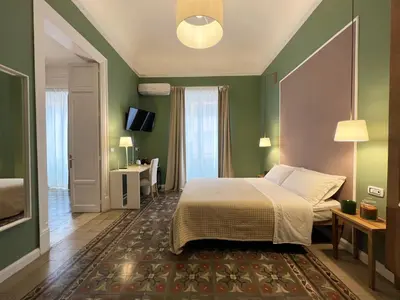 a bedroom with a bed and a green wall at Bed in Spa in Palermo