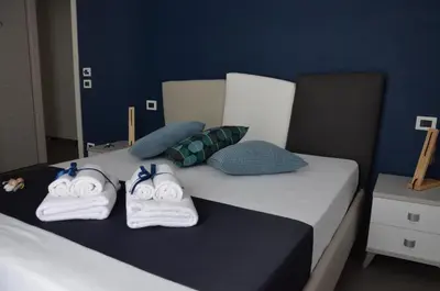 a bedroom with two beds with towels and pillows at L'Angolo Dello Zio in San Vito lo Capo