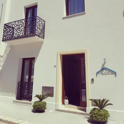 a white building with a door and a balcony at L'Angolo Dello Zio in San Vito lo Capo
