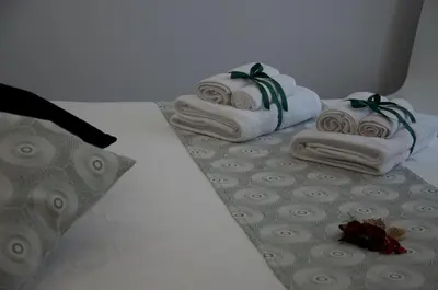 a bed with three towels and a pillow on it at L'Angolo Dello Zio in San Vito lo Capo