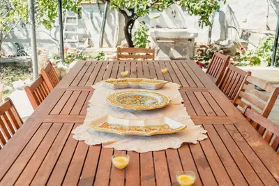 a wooden table with a plate of food on it at B&B Elvira Al Duomo in Monreale