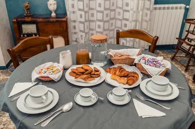 a table with plates of pastries and cups on it at B&B Elvira Al Duomo in Monreale