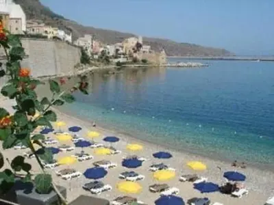 a group of umbrellas on a beach near the water at Veranda sul Mare in Castellammare del Golfo