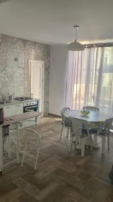 a kitchen and dining room with a table and chairs at Veranda sul Mare in Castellammare del Golfo