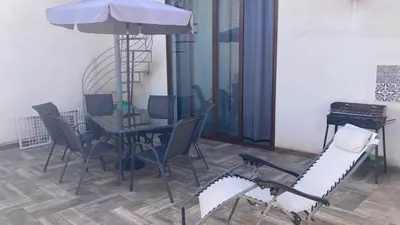 a dining room with a table and chairs and an umbrella at Veranda sul Mare in Castellammare del Golfo