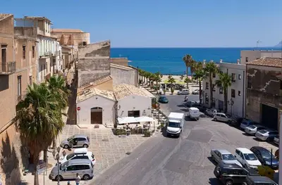 a city street with cars parked in a parking lot at Veranda sul Mare in Castellammare del Golfo