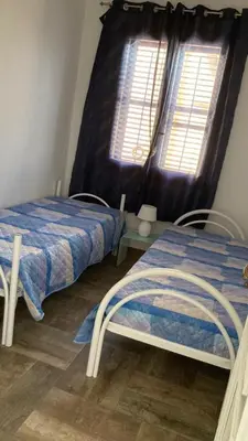 a bedroom with two beds and a window at Veranda sul Mare in Castellammare del Golfo
