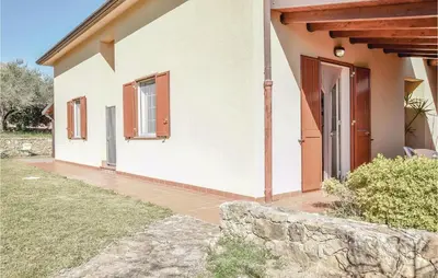 a white house with a door and a stone wall at Casa Giuseppa in Mandra Capreria