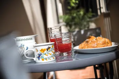 a table with a plate of food and a glass of juice at A&G Dimore di Famiglia - Un Lusso Garbato in Palermo