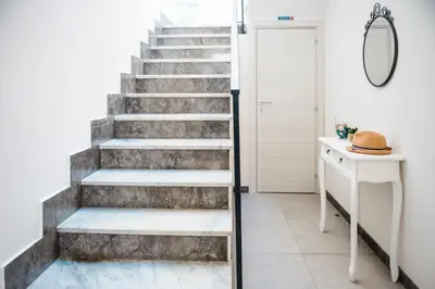 a staircase in a room with a hat and a table at BENVENUTI AL SUD in Castellammare del Golfo
