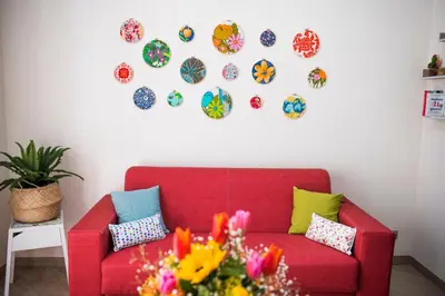 a red couch in a living room with plates on the wall at BENVENUTI AL SUD in Castellammare del Golfo