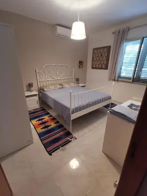 a bedroom with a bed and a rug at Villetta immersa nel verde ma vicina al mare in Lascari