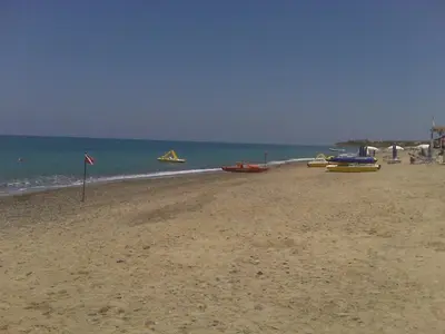 a sandy beach with boats on the water at Villetta immersa nel verde ma vicina al mare in Lascari