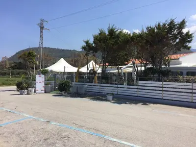 a parking lot with a white fence and tents at Villetta immersa nel verde ma vicina al mare in Lascari
