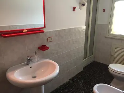 a bathroom with a sink and a toilet at Villetta immersa nel verde ma vicina al mare in Lascari