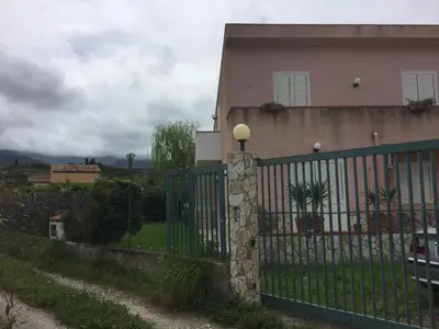 a fence in front of a house at Villetta immersa nel verde ma vicina al mare in Lascari