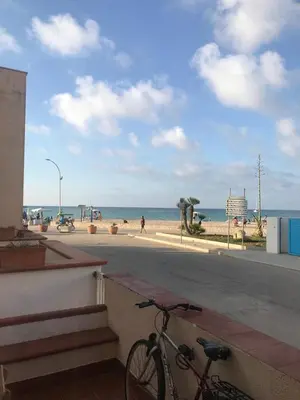 a bike parked on the side of a building near the beach at Sul lungo mare posizione unica in San Vito lo Capo