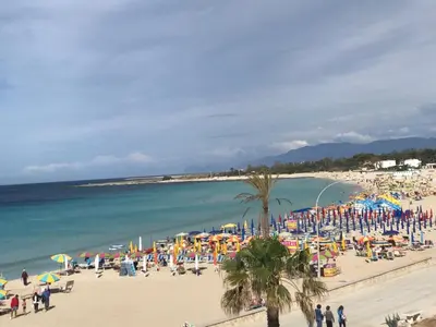 a group of people on a beach with umbrellas at Sul lungo mare posizione unica in San Vito lo Capo