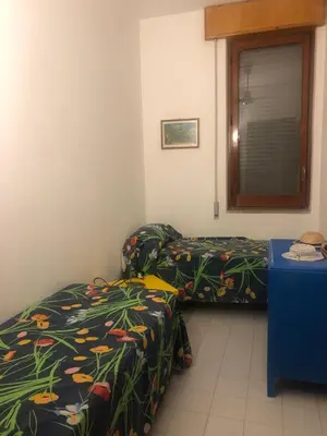 a room with two beds and a table at Sul lungo mare posizione unica in San Vito lo Capo