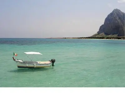 a boat in the middle of a body of water at Sul lungo mare posizione unica in San Vito lo Capo