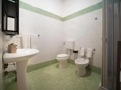a bathroom with a toilet and a sink at Kalamarina Rooms in Palermo