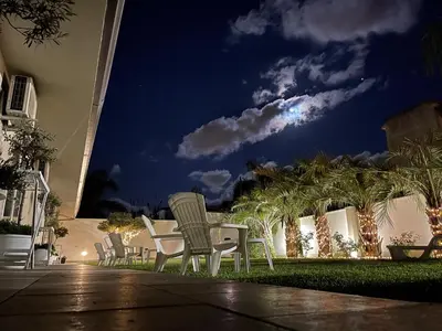 a group of chairs sitting on a patio at night at Amantea Monument in Terrasini