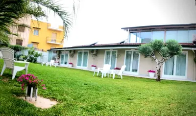 a yard with white chairs and a building at Amantea Monument in Terrasini