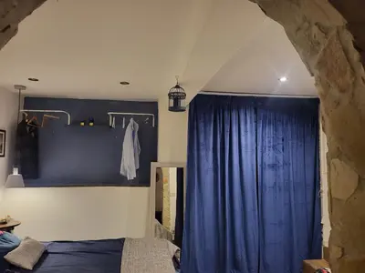 a bedroom with a blue curtain and a bed at Il Rifugio in Palermo