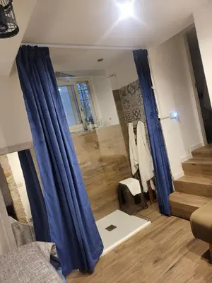 a living room with blue curtains and a staircase at Il Rifugio in Palermo