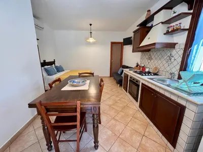 a kitchen and dining room with a table and chairs at Monolocale da Mariolina in Macari