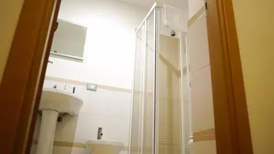 a bathroom with a sink and a glass shower at LE PORTE DI PALERMO in Palermo